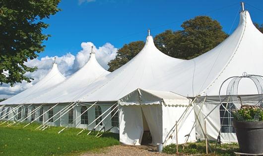 tall green portable restrooms assembled at a music festival, contributing to an organized and sanitary environment for guests in Drummonds